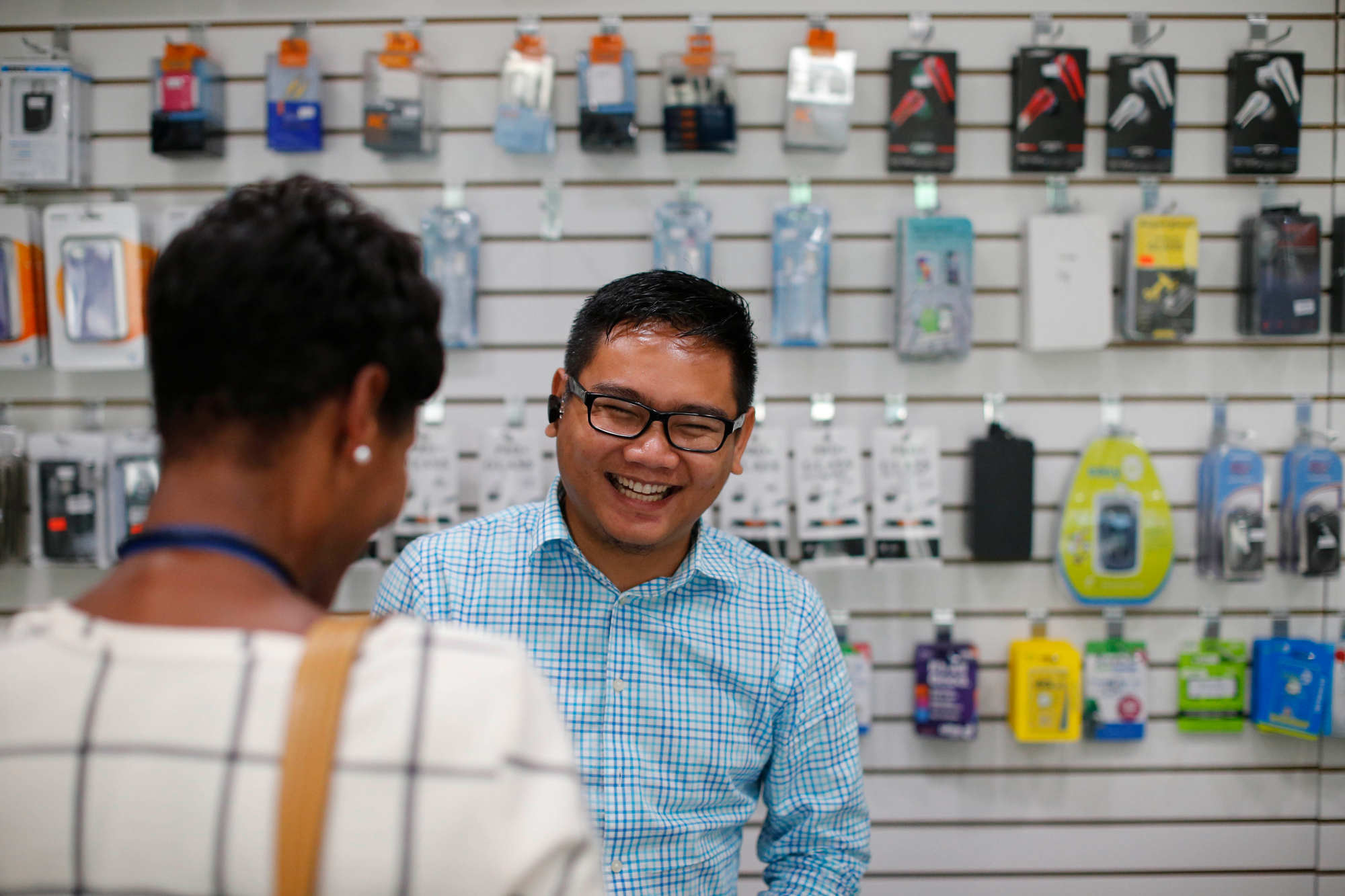 Aung Kaung Myat helps a customer at the counter of his iT Garden store on Grant Street, Sept. 20, 2016. (Derek Gee/Buffalo News)