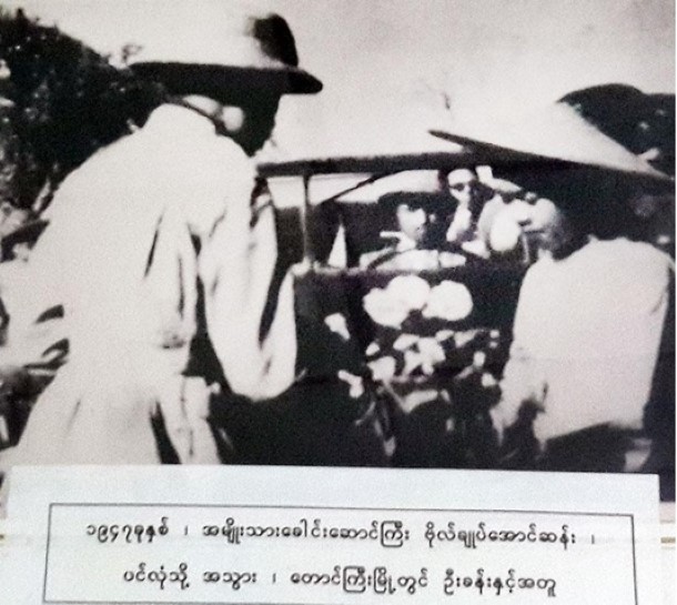 U Khan is pictured in 1947 sitting behind the steering wheel while Aung San, left, receives a bouquet from a young woman in Taunggyi before heading to Panglong.