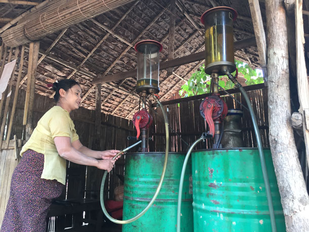 A purveyor of petrol fills canisters at a small station in Bilin Township, Mon State. (Photo: Saw Yan Naing / The Irrawaddy)