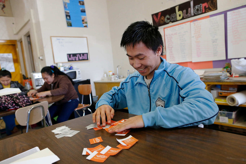 Henry Zayamoe, 21 when this photo was taken in 2015, a refugee from Shan State, Burma who moved to Buffalo one year ago, participates in a class project during social studies class in the Making a Connection program, a program for refugee teens designed to help them achieve advanced English skills and a GED for students who would age out of traditional high school before earning enough credits for a diploma, April 1, 2015. (Derek Gee / Buffalo News)