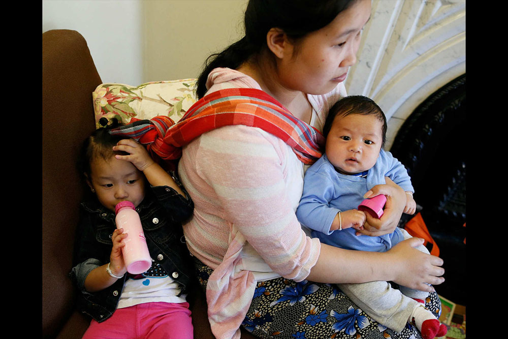 Bu Meh, a Karenni refugee from Burma, has her daughter, Cecilia Meh, 2, and 2-month-old son Nathan David in tow during an open session with a Burmese-speaking doula at The Priscilla Project, a program to help pregnant women and new mothers through childbirth and parenting as new Americans, June 11, 2015. (Derek Gee / Buffalo News)