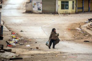 A lone woman carries her possessions through the deserted streets of Laukkai in mid-February after clashed broke out in the area between the MNDAA and the Myanmar Army.