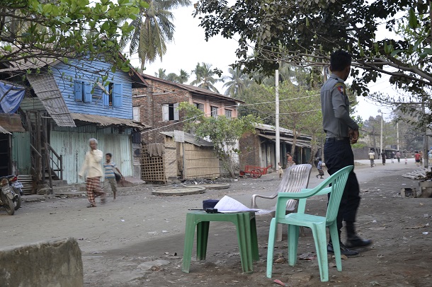 A policeman keeps watch in Aung Minglalar, Sittwe, where security checkpoints and encampments remain, more than three years after 2012 riots shook the city. (Photo: Thu Mratt) 